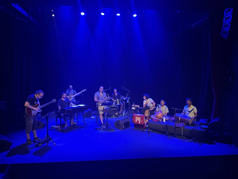 Musicians on a stage lit in blue